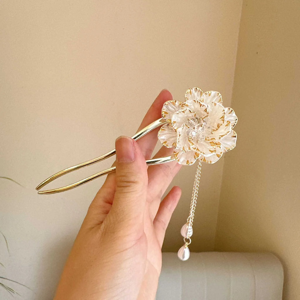 Close-up of a retro-style U-shaped alloy hairpin with a detailed peony flower and tassel design, shown in a purple electroplated finish.