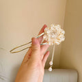 Close-up of a retro-style U-shaped alloy hairpin with a detailed peony flower and tassel design, shown in a purple electroplated finish.