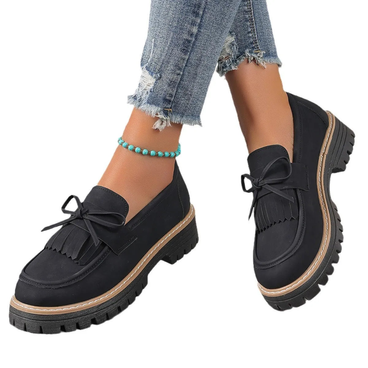 Women's black plus size loafers with tassel decoration and a chunky rubber sole.