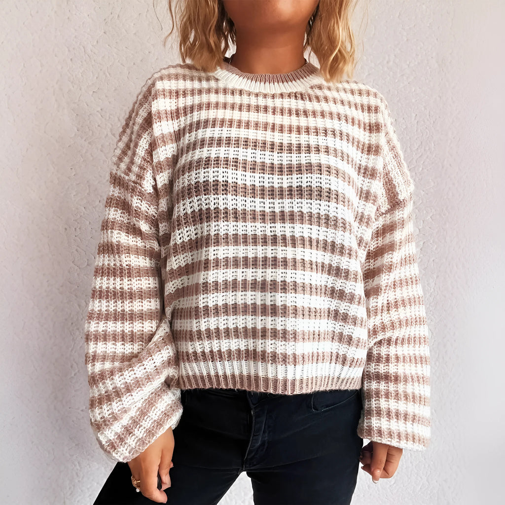 A woman wearing a vintage-style black and white striped loose-fit pullover sweater.