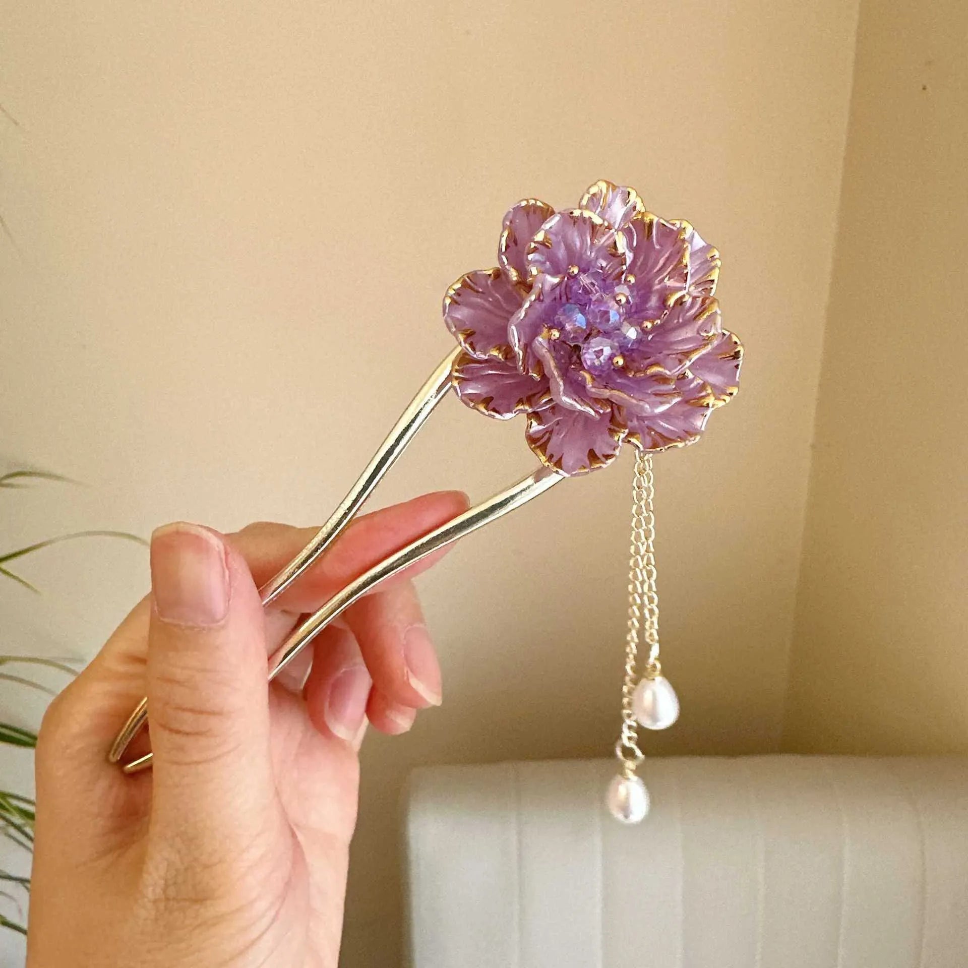 Close-up of a retro-style U-shaped alloy hairpin with a detailed peony flower and tassel design, shown in a purple electroplated finish.