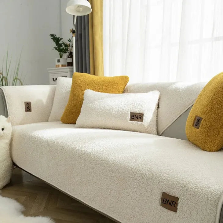Solid colour lambswool sofa cover on a couch with matching pillow cover.