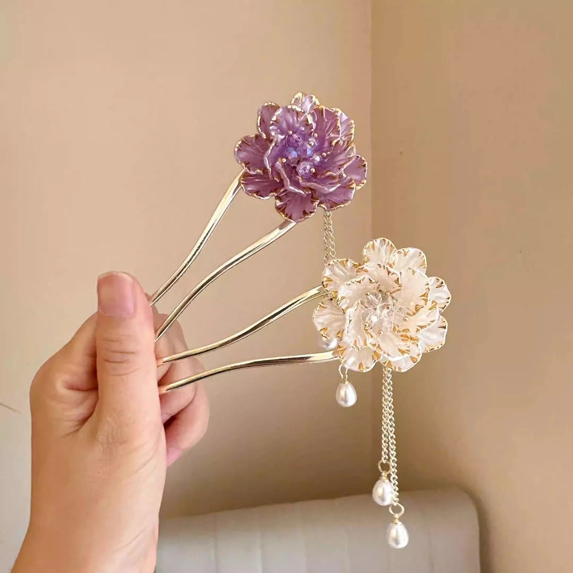 Close-up of a retro-style U-shaped alloy hairpin with a detailed peony flower and tassel design, shown in a purple electroplated finish.