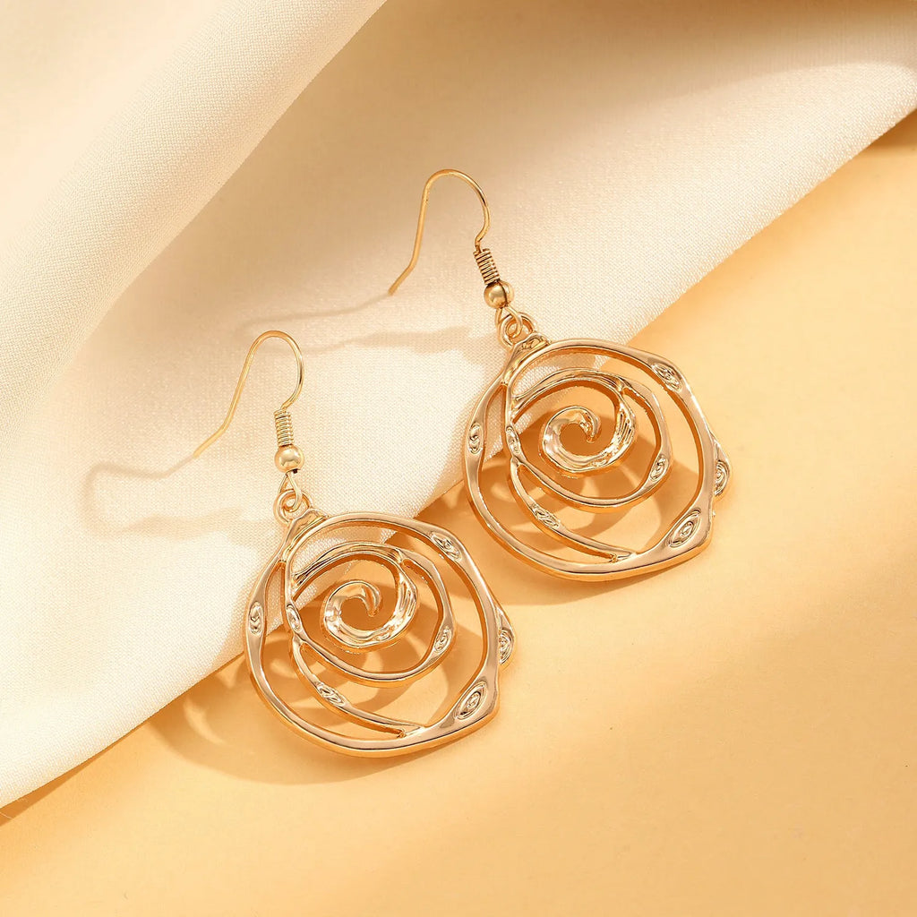 Spiral donut jewellery set showing gold tone necklace, bracelet and earrings with geometric circular design