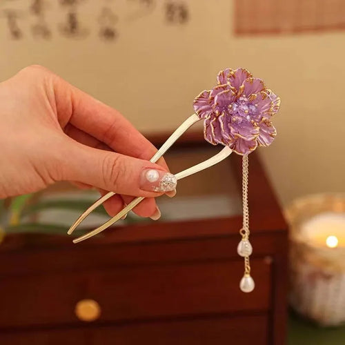 Close-up of a retro-style U-shaped alloy hairpin with a detailed peony flower and tassel design, shown in a purple electroplated finish.