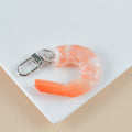 Close-up of a white simulation shrimp PVC keychain pendant showing its 1.5cm thickness.