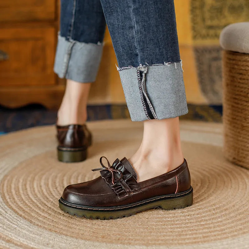Women's black round-toe leather shoes with a chunky flat heel and lace-up front.