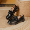 Women's black round-toe leather shoes with a chunky flat heel and lace-up front.