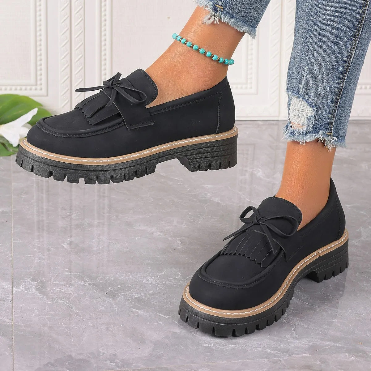 Women's black plus size loafers with tassel decoration and a chunky rubber sole.