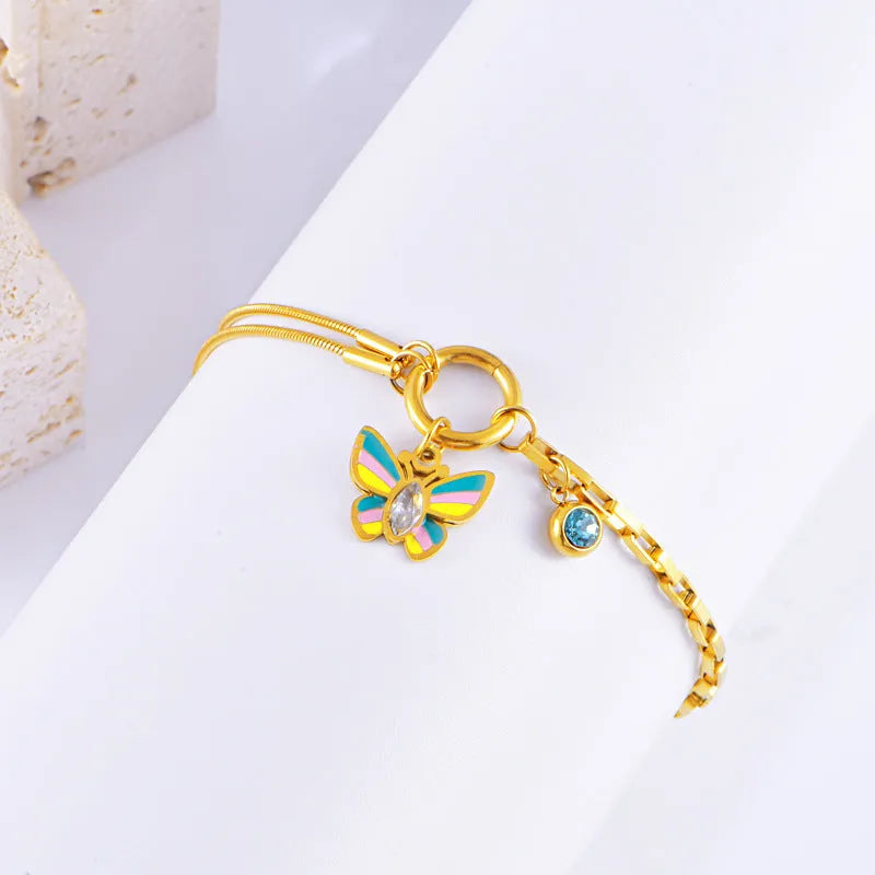 Gold-coloured titanium steel butterfly jewellery set with necklace and bracelet showing epoxy resin pendants