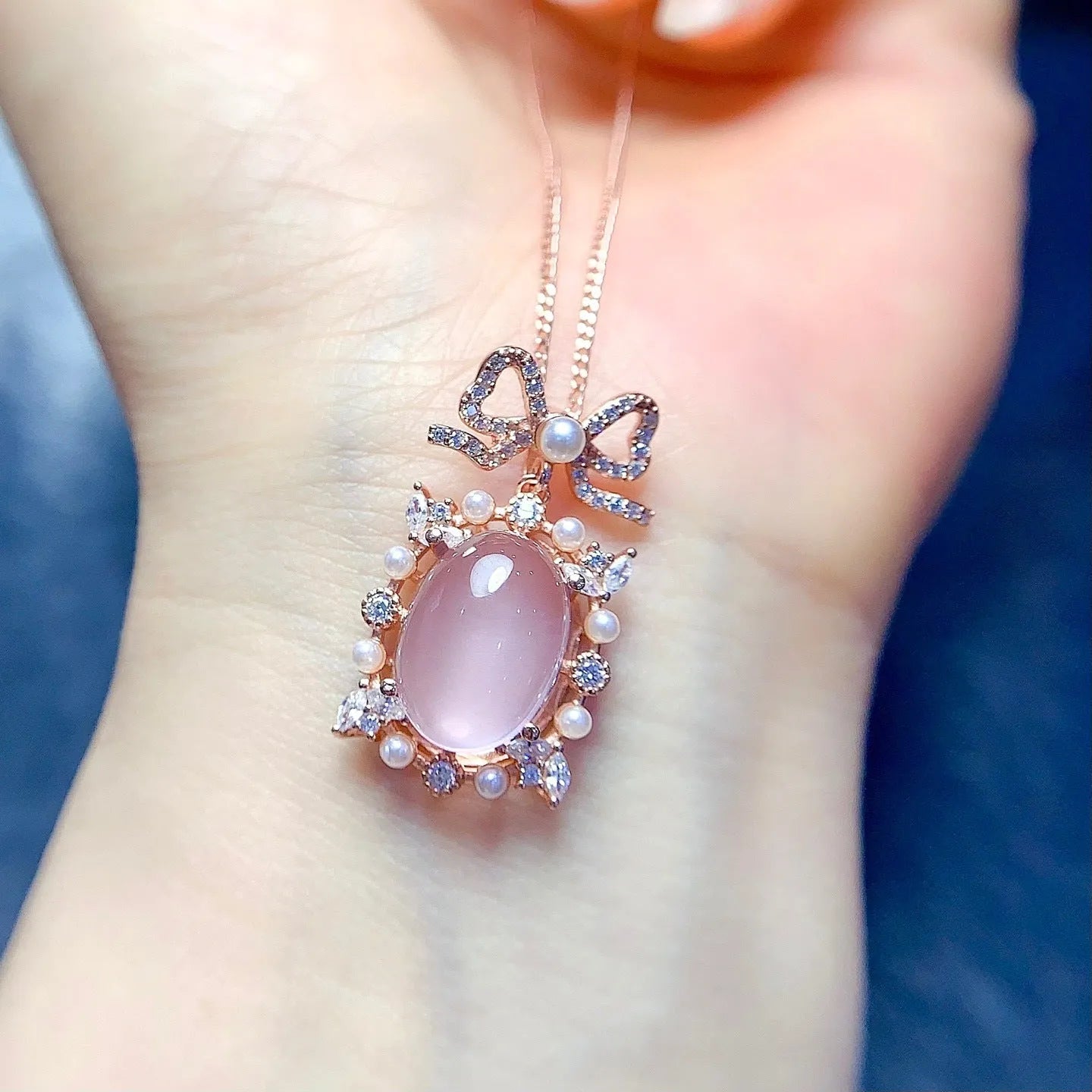 Geometric silver pendant necklace with a pink rose quartz crystal and rose gold plating.