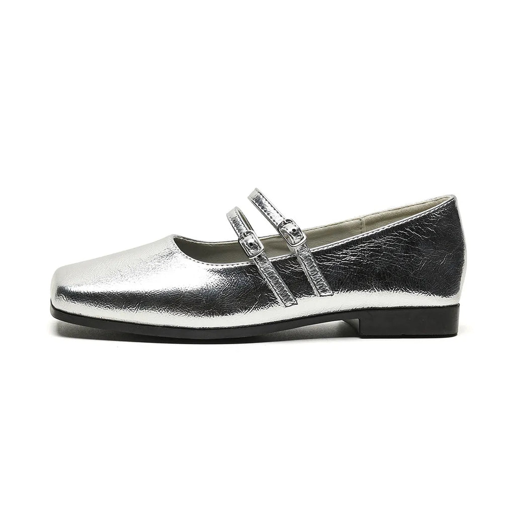 Women's silver sheepskin leather ballet flats with a cross buckle strap and round toe, shown on a plain background.