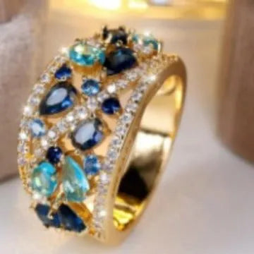Women's round hollow copper fashion ring with a choice of platinum or gold finish and white or blue stone.