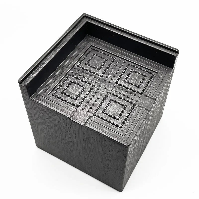 Four black plastic circular furniture riser feet on a floor