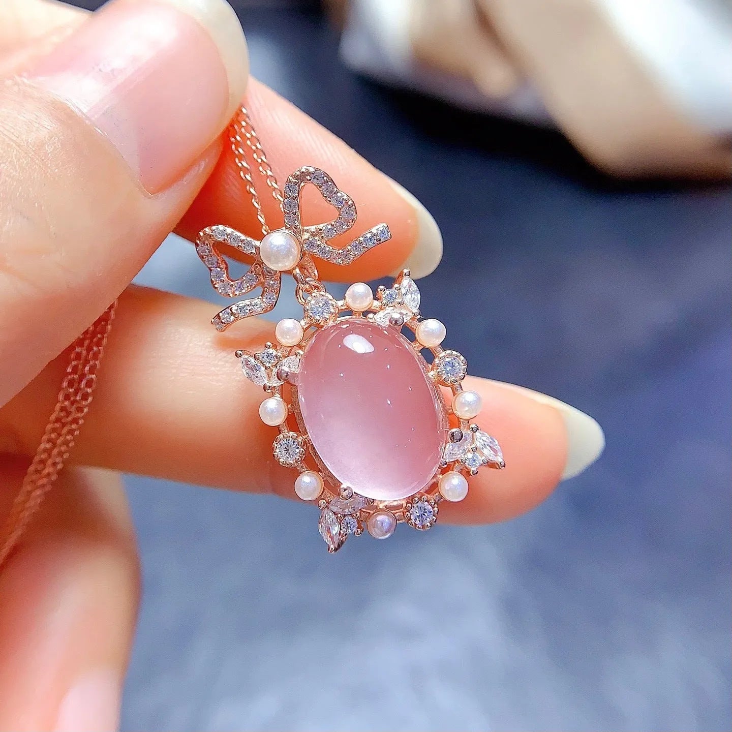 Geometric silver pendant necklace with a pink rose quartz crystal and rose gold plating.