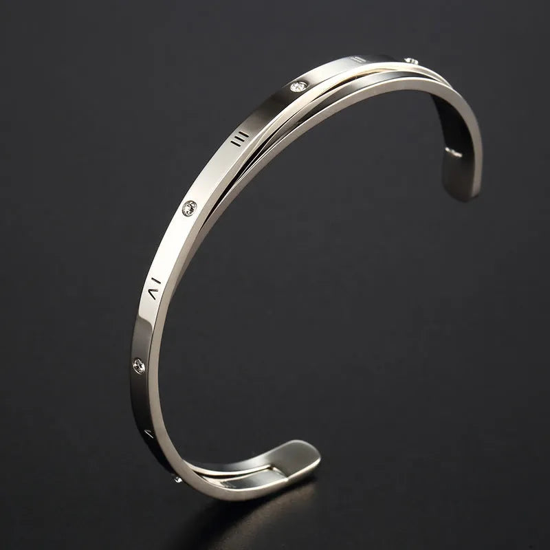 Open-ended women's bracelet in stainless steel with electroplated finish and inlaid zircon stones.
