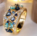 Women's round hollow copper fashion ring with a choice of platinum or gold finish and white or blue stone.