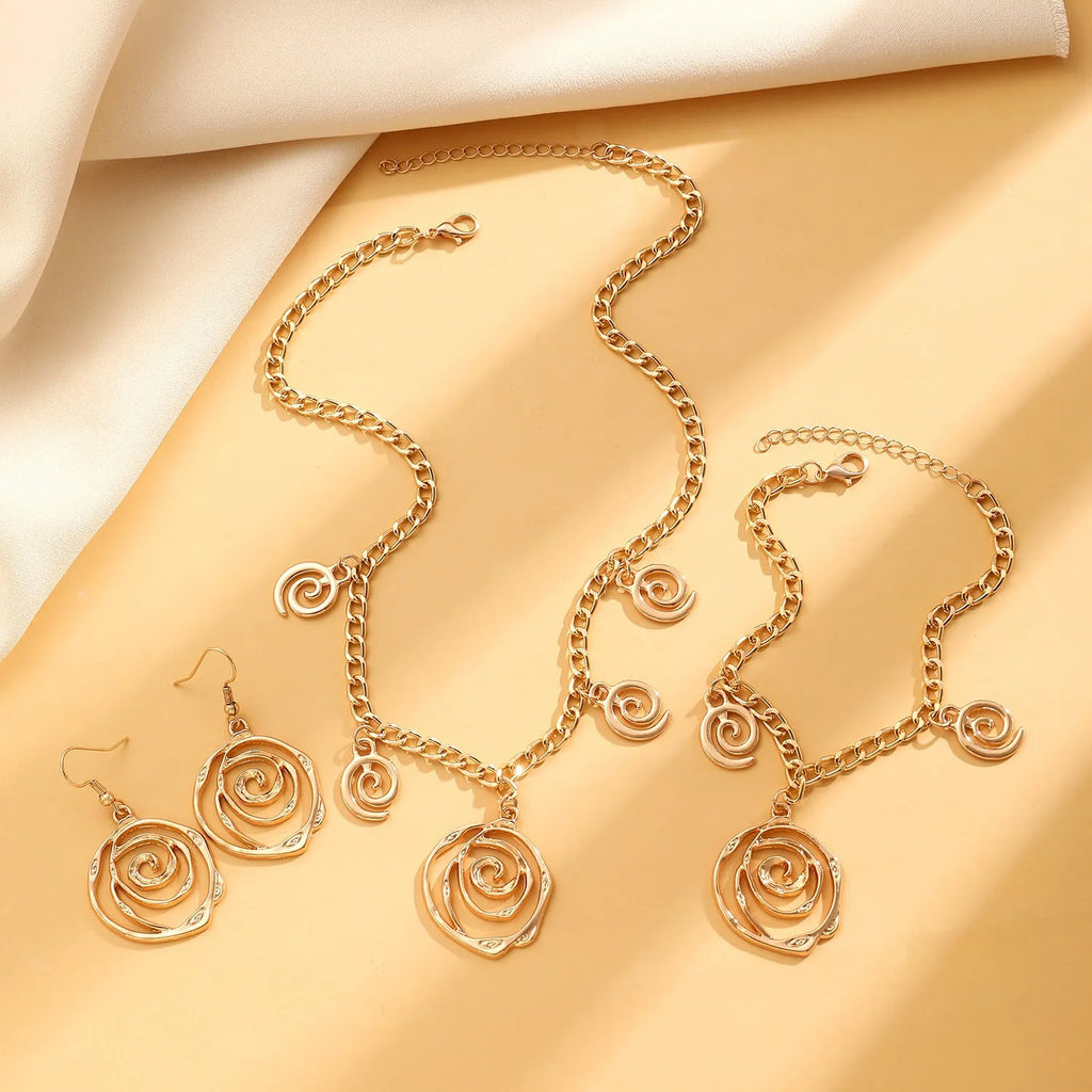 Spiral donut jewellery set showing gold tone necklace, bracelet and earrings with geometric circular design