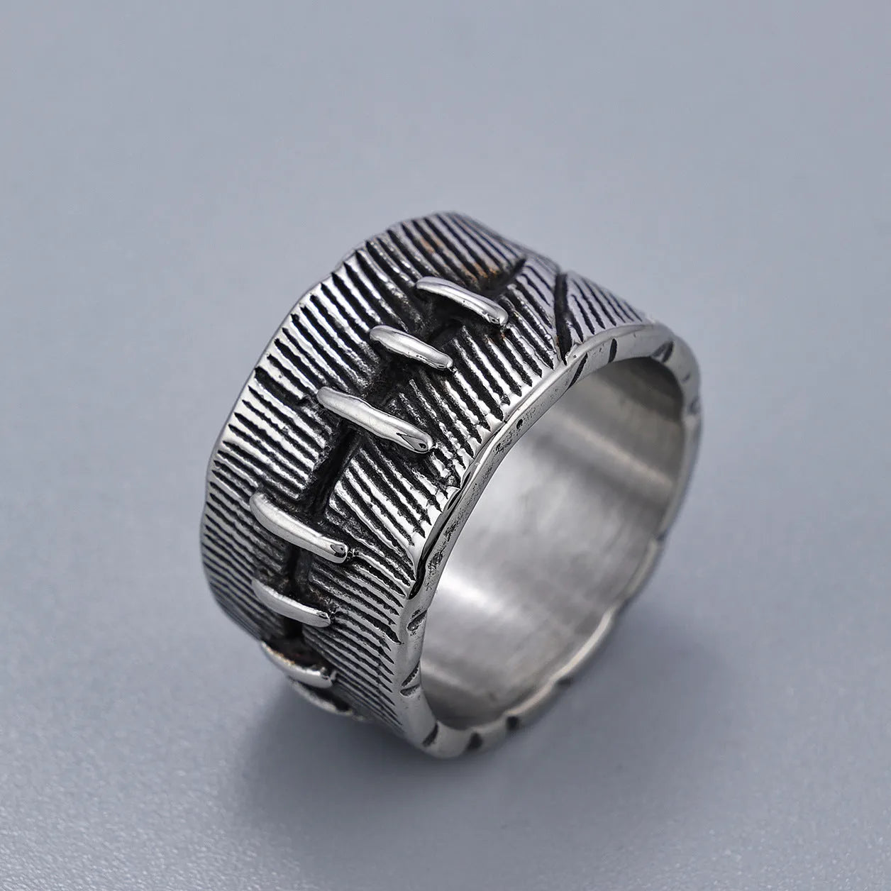 Geometric U-shaped titanium steel punk ring with double-ring design and stitched texture in black.
