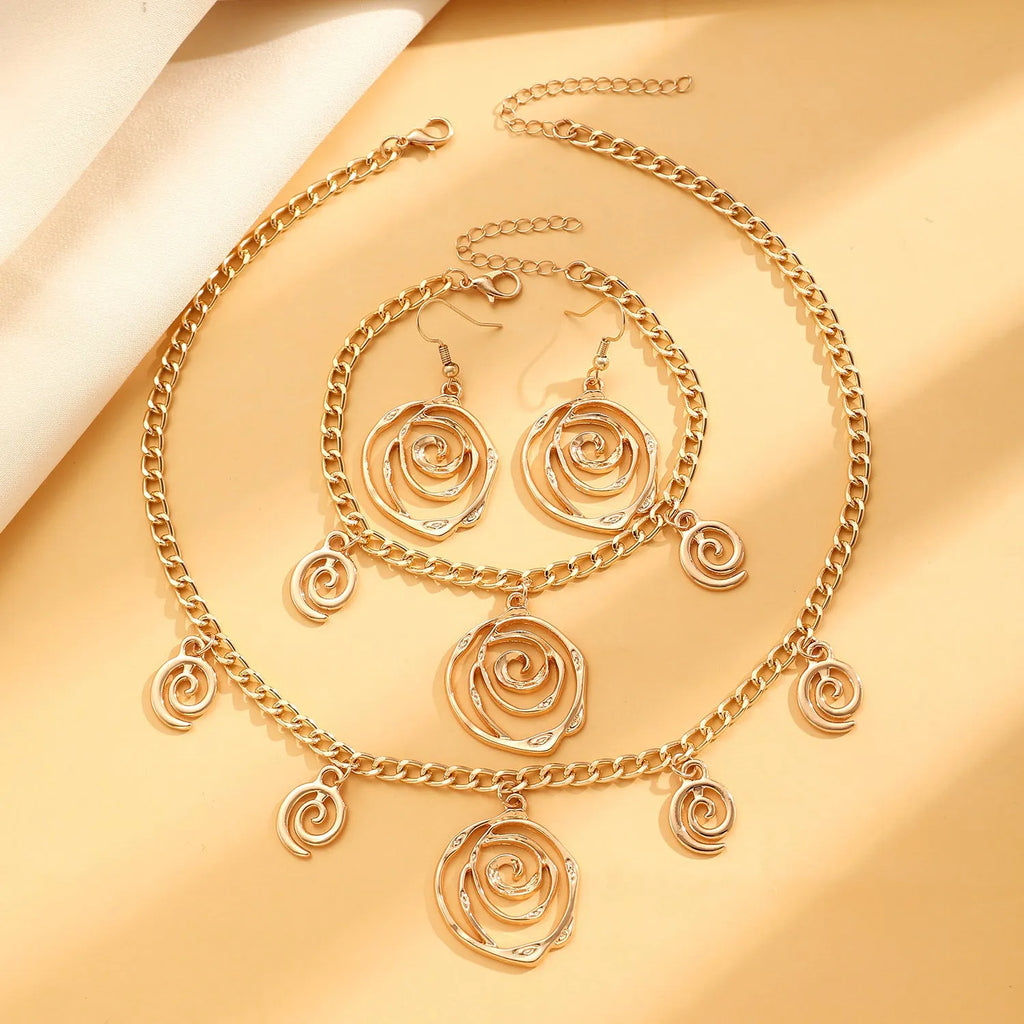 Spiral donut jewellery set showing gold tone necklace, bracelet and earrings with geometric circular design