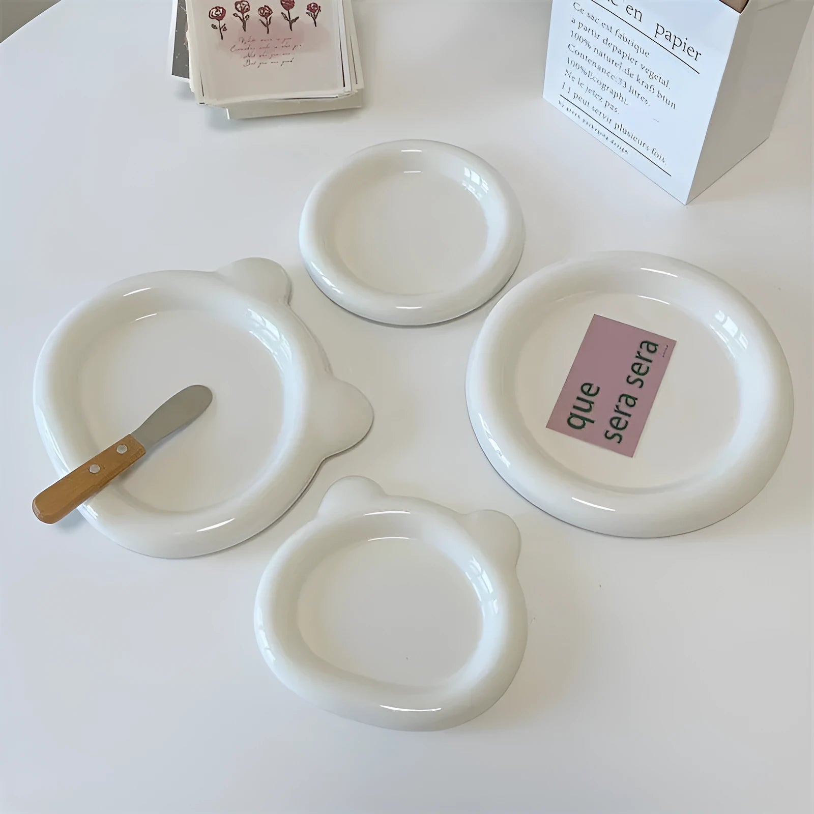 White ceramic chubby toot plate with doodle design, shown in bear and round styles.