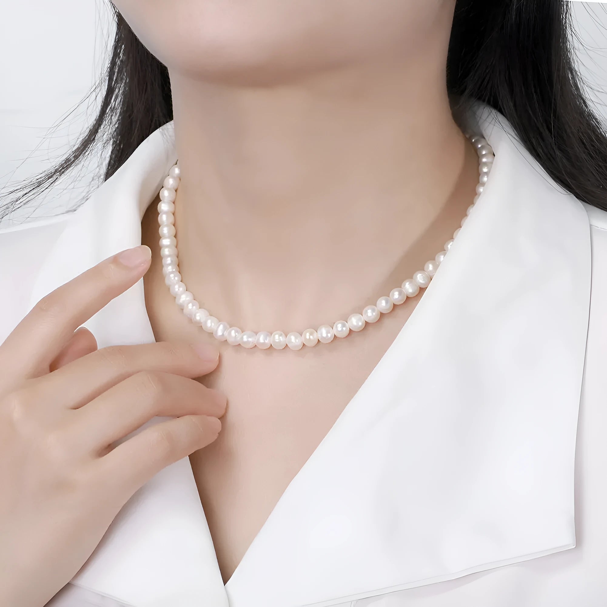 Close-up of a women's adjustable necklace with a round natural freshwater pearl on a silver chain.