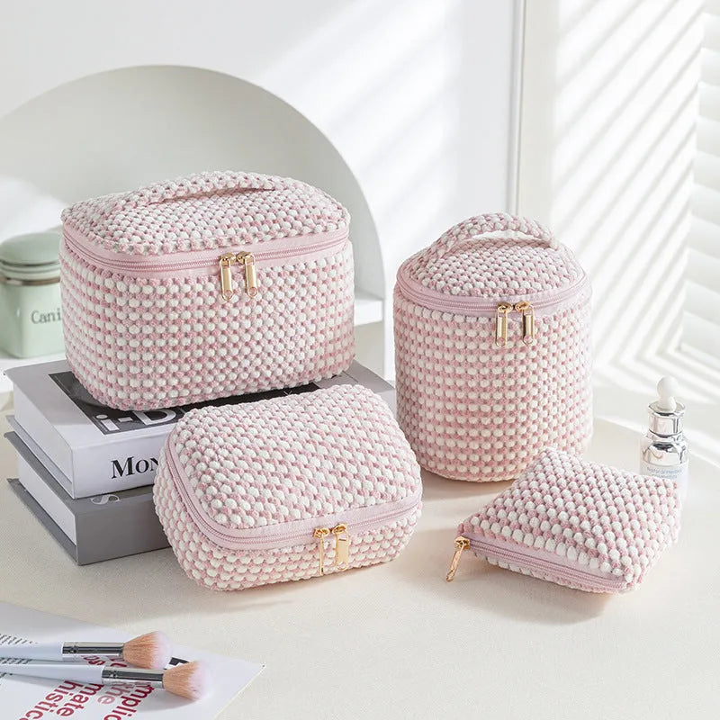 Four cube-style polyester makeup bags in blue with dots, khaki, pink, and pink dots colours arranged together