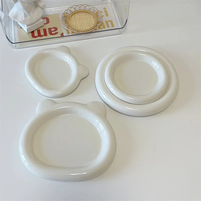 White ceramic chubby toot plate with doodle design, shown in bear and round styles.