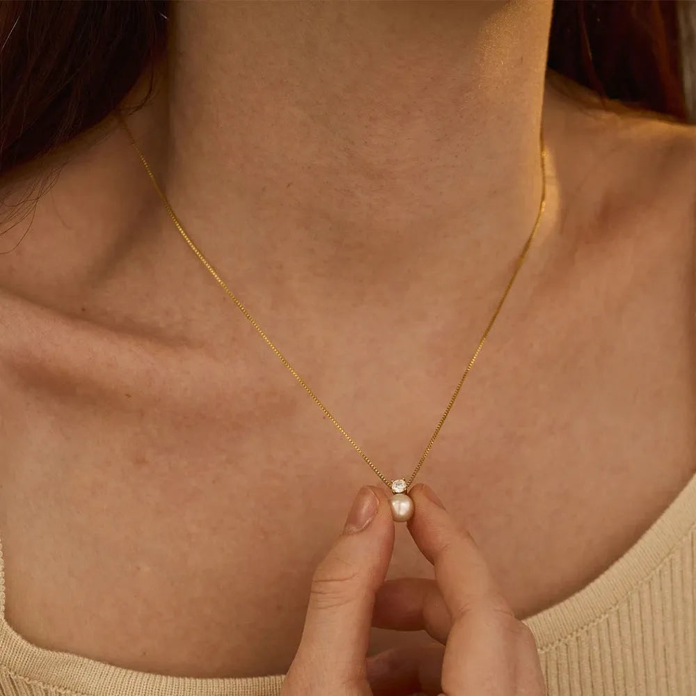 Simple stainless steel necklace for women with imitation pearl and zircon pendant in New Chinese style.