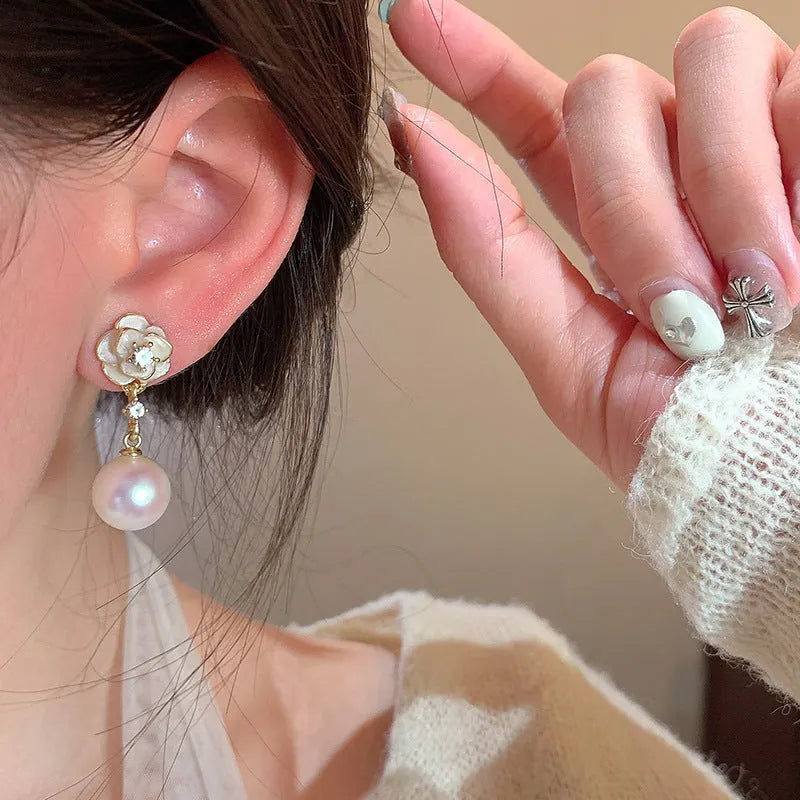 Close-up of camellia flower stud earrings for women showing alloy metal construction and floral detailing