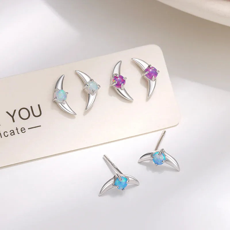 A pair of geometric-shaped 925 silver earrings with a gold colour electroplate and a blue cubic zirconia stone.