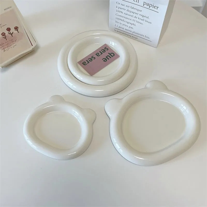 White ceramic chubby toot plate with doodle design, shown in bear and round styles.