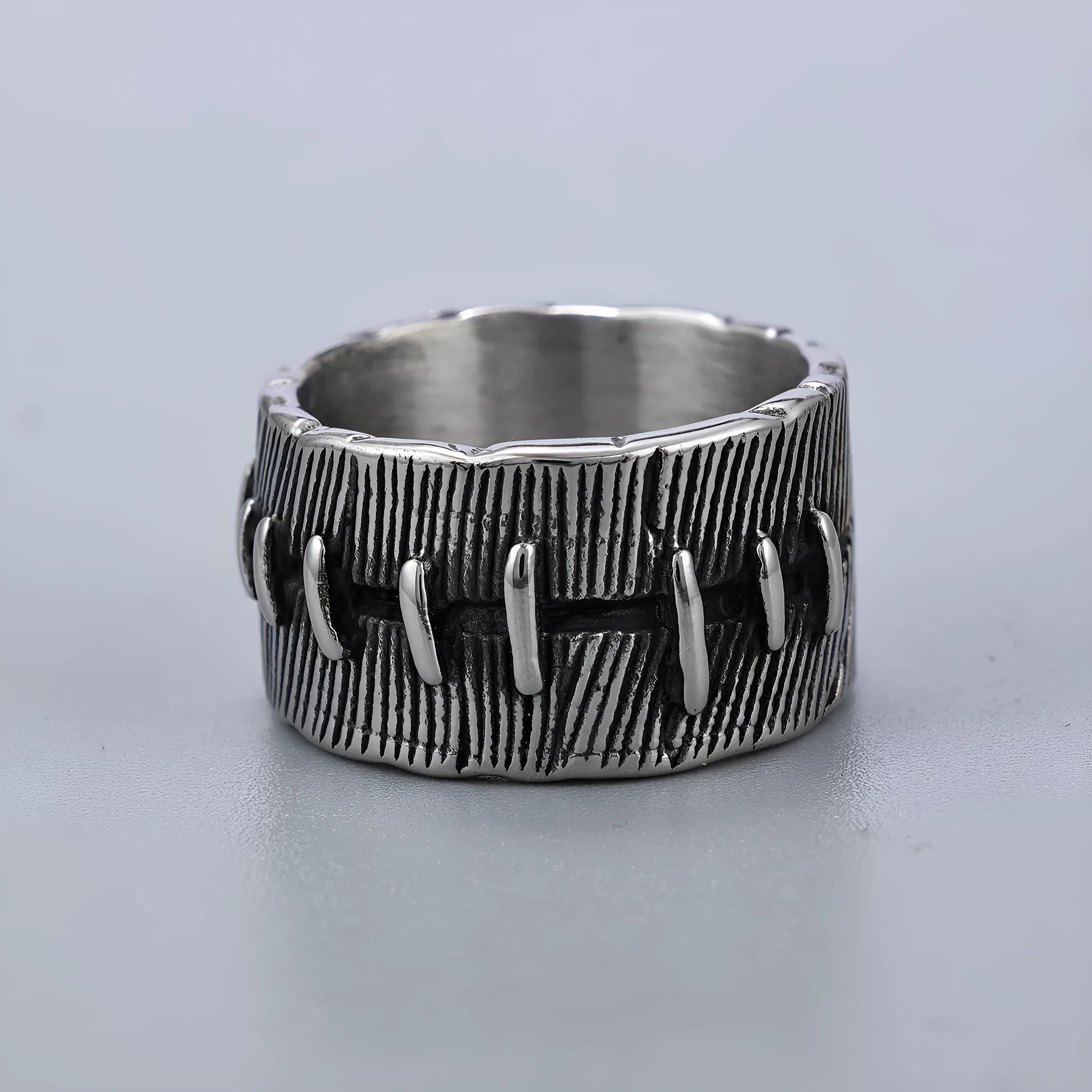 Geometric U-shaped titanium steel punk ring with double-ring design and stitched texture in black.