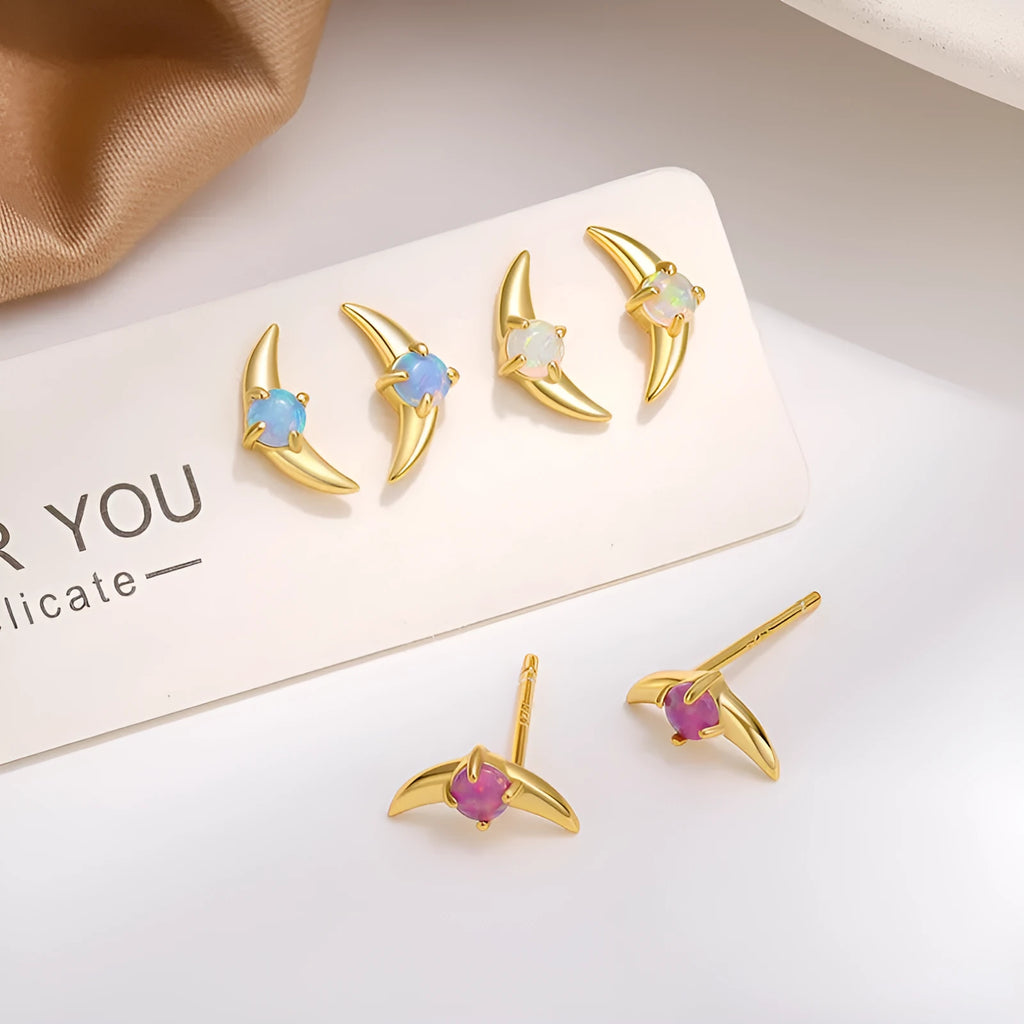 A pair of geometric-shaped 925 silver earrings with a gold colour electroplate and a blue cubic zirconia stone.