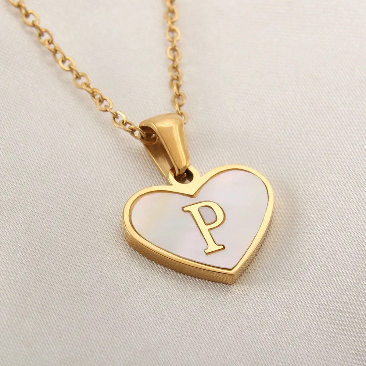 Gold plated heart-shaped white shell pendant personalised initial necklace on a stainless steel chain.