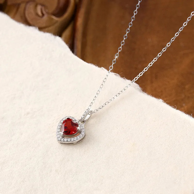 Heart-shaped sterling silver pendant necklace with a natural gemstone on an adjustable chain.