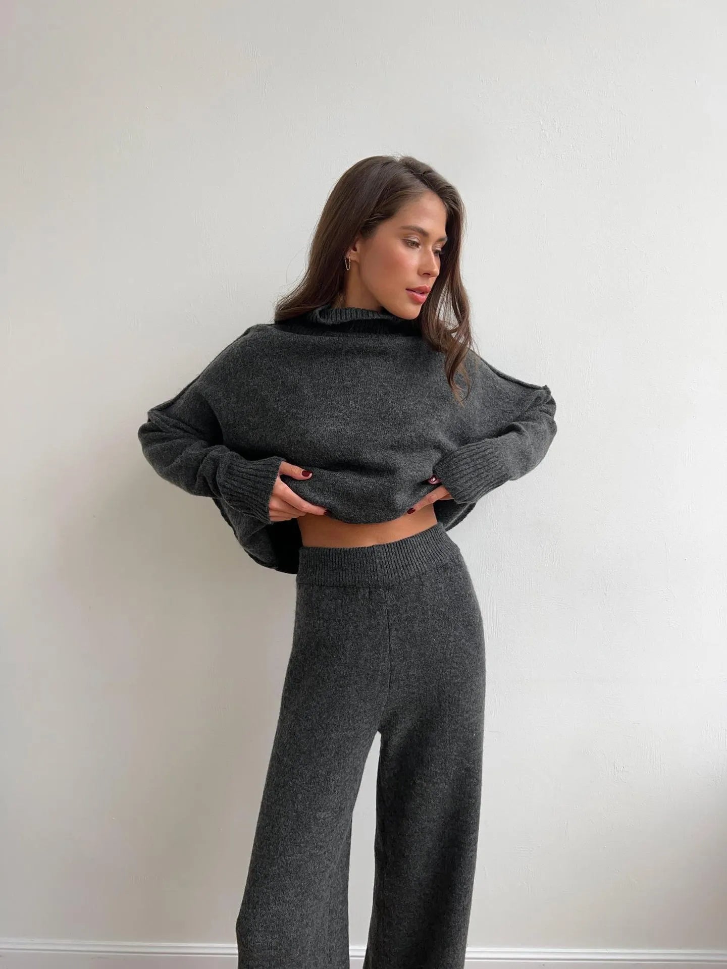 Women's acrylic suit set showing side-slit sweater top with matching trousers in solid colour