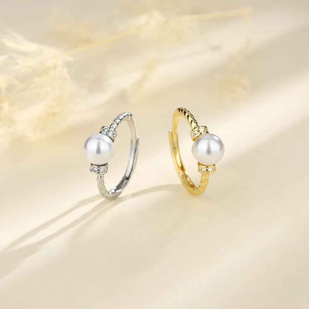 Adjustable antique twist ring with a pearl inlay, shown in gold and silver copper finish.