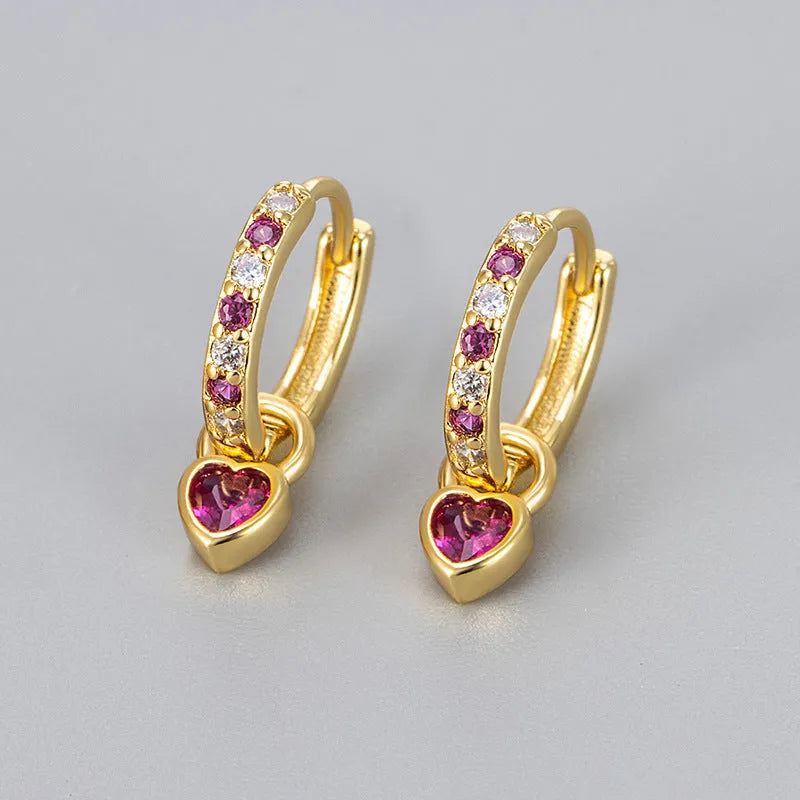 A pair of women's heart-shaped clip earrings with a coloured gemstone centre, available in gold or white gold colour metal.