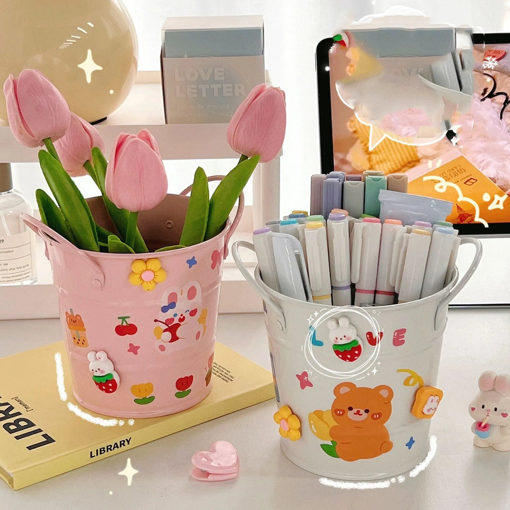 Round metal Creative Iron Art pen holder shown in pink, green, red, white, and yellow colour options on a desk.