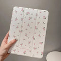 Clear tri-fold iPad case with floral design, shown in stand mode.