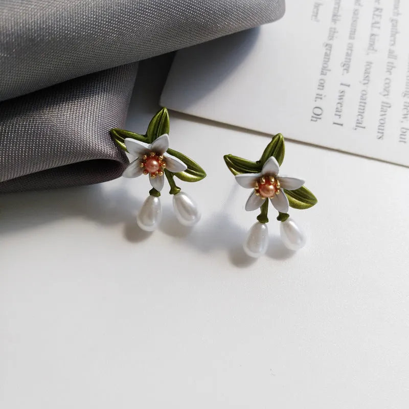 Women's alloy flower earrings set showing sterling silver needle flower studs and matching flower ear clip pair