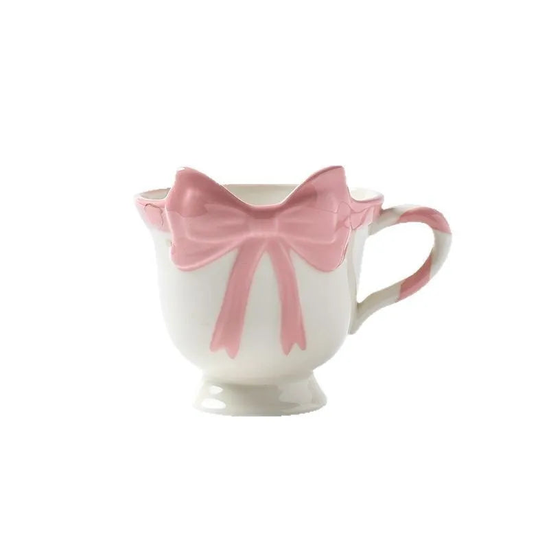 Ceramic mug with a heart and bow design in black pink and white powder colour options.