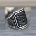 Black alloy ring with copper inlay and zircon detail on a finger, showing unisex design.