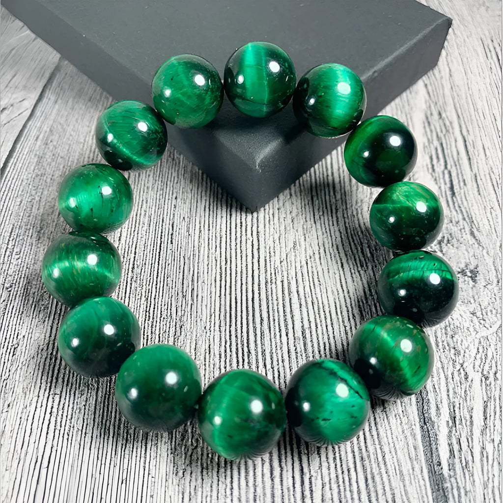 Polished green tiger eye stone bead bracelet on a wrist, showing geometric bead shapes.