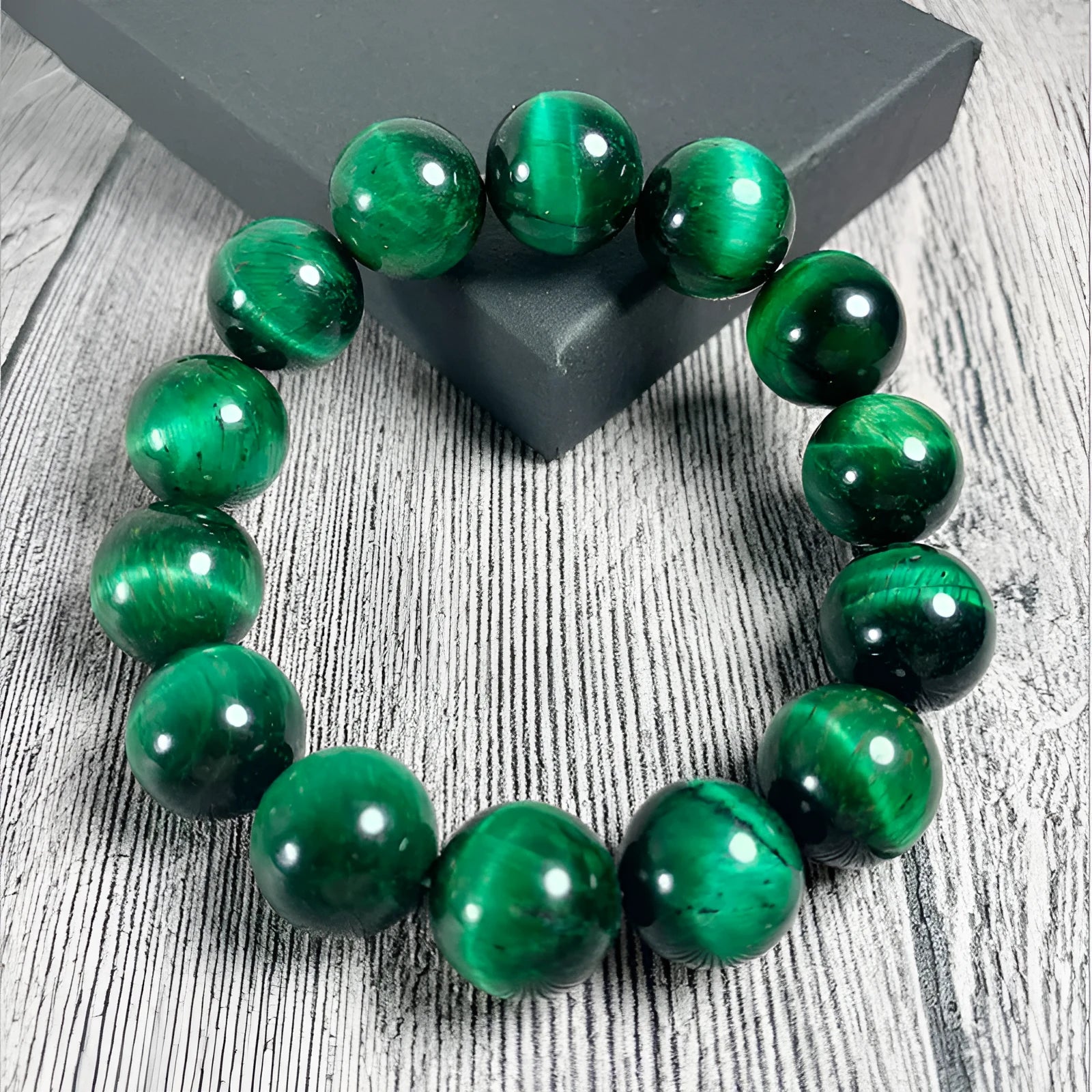 Polished green tiger eye stone bead bracelet on a wrist, showing geometric bead shapes.