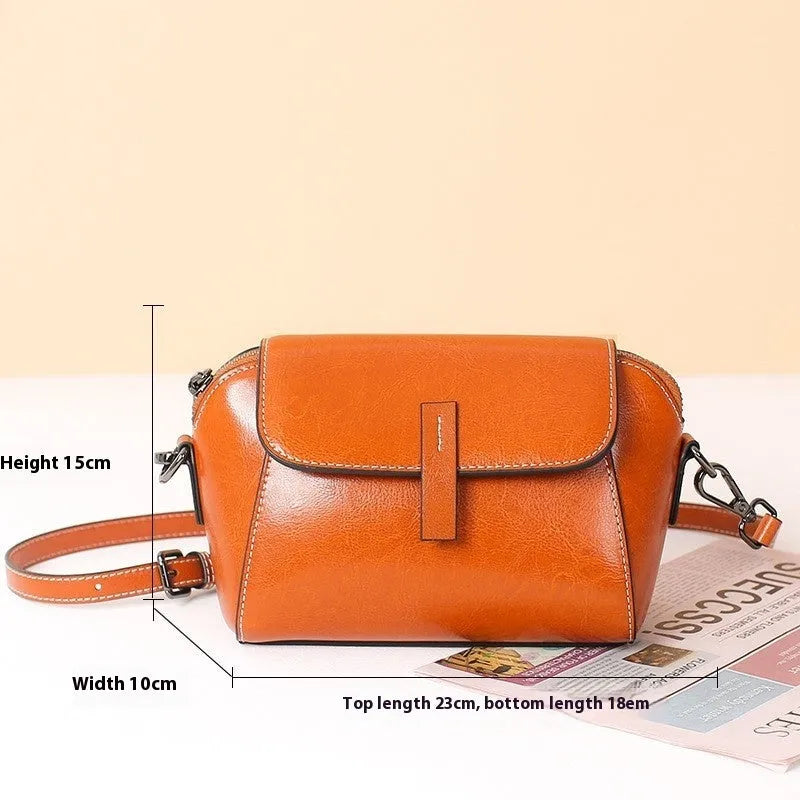 Brown genuine leather women's messenger bag with cross-body strap showing internal zipper compartments