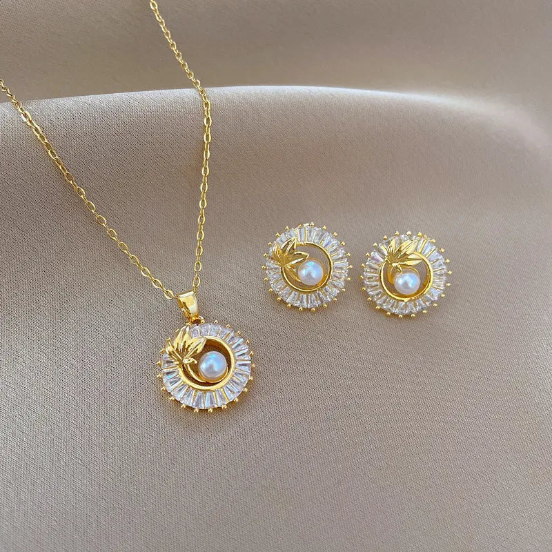 Women's geometric jewellery set showing necklace and earrings with ring and leaf designs in gold and silver tones