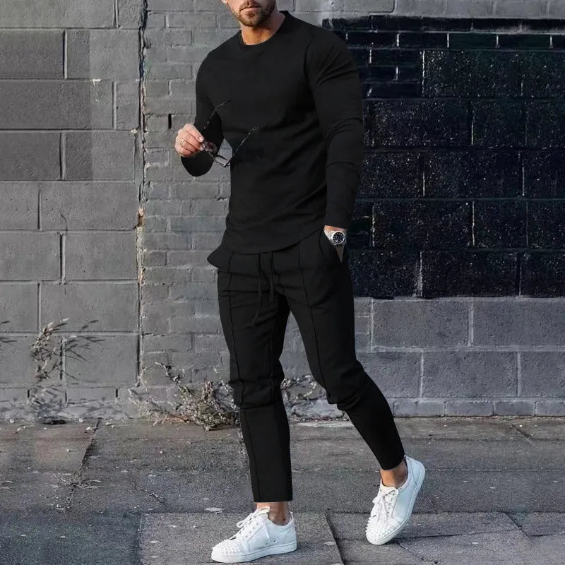 Man wearing a light grey round-neck long-sleeve t-shirt and matching trousers from a two-piece polyester suit set.