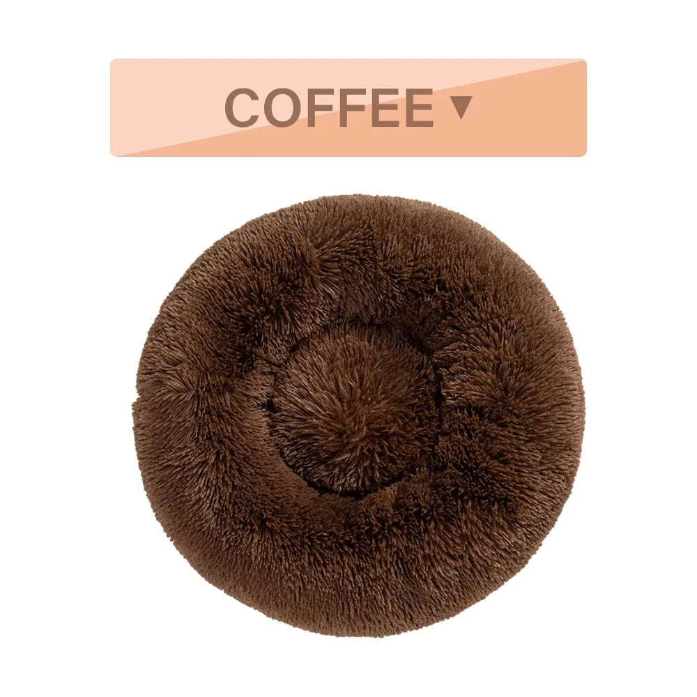 Fluffy donut-shaped dog bed in long plush fabric, shown in a light grey colour with a raised edge.